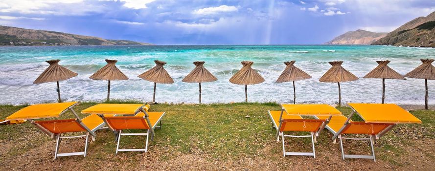 Idyllic beach in Baska sun shades view, Island of Krk, Croatia. Baska is famous tourist destination in Croatia.