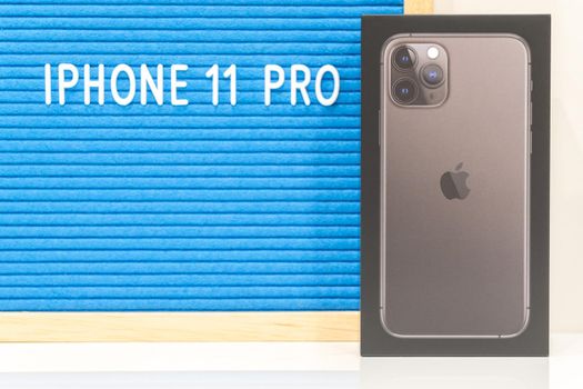 Moscow, Russia - September 24, 2019: Apple iPhone 11 pro in a box standing near letter board