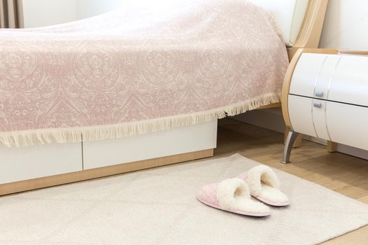Bedroom in modern style with pink cozy soft slippers on floor