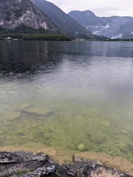 Alpine lake Hallstatter See during rain, raindrops on the water surface