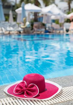 Nice pink hat with a bow near the pool