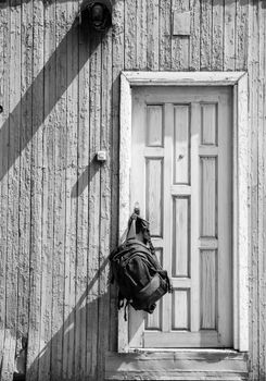 Backpack hanging on door, black and white