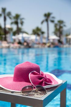 Nice pink hat with a bow near the pool