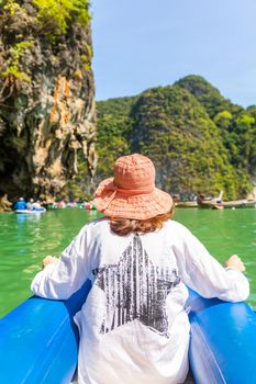 Waman wearing orange hat sailing in boat in Thailand