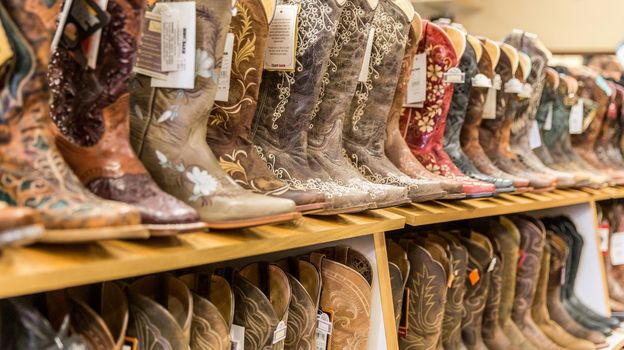 LOS ANGELES, CALIFORNIA, USA - MAY 20, 2015 - Close-up of new cowboy boots on shelf in Boot Barn store