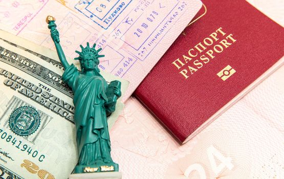 Passport, money and small statue of liberty