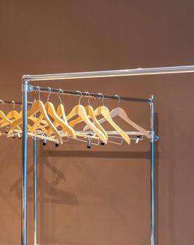 Wooden hangers on coat rack with no clothes in empty cloakroom