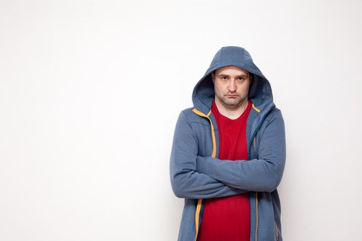 Man on white background. A man with a red sweater and a blue jacket, with a hood.