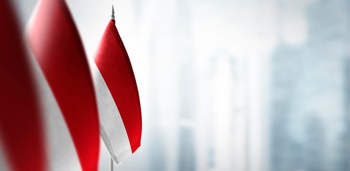 Small flags of Indonesia on a blurry background of the city.