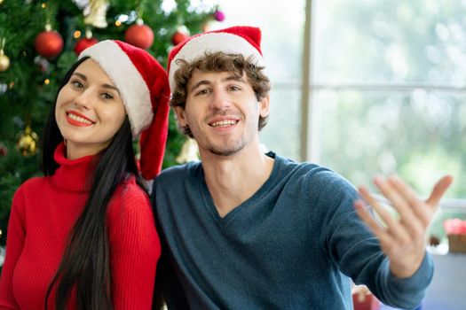 Couple man and woman smile and look at camera during Christmas festival.