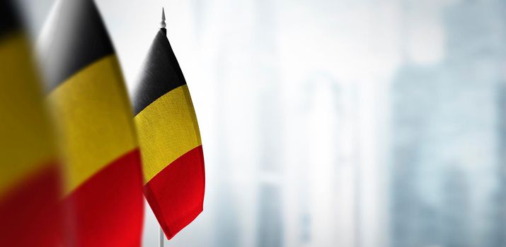 Small flags of Belgium on a blurry background of the city.