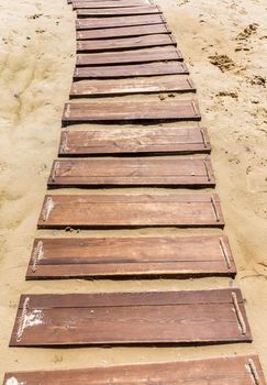 Wooden beach boardwalk, path with sand with copy space