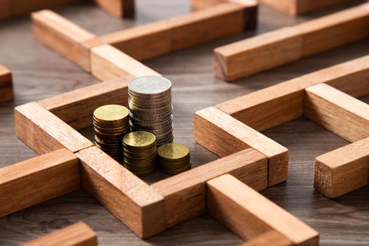 Group of coins heaps in the maze game built by wood blocks, find a way to money resource, business budget, making money concept
