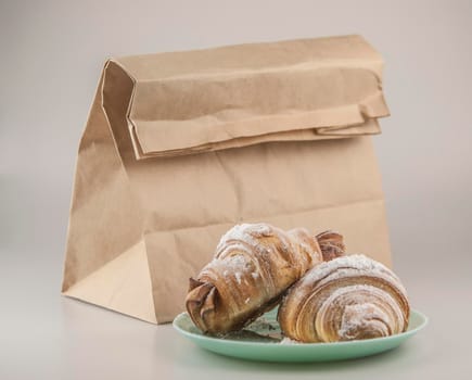 Two fresh croissants in plate on white background. Breakfast