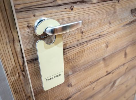 Please do not disturb sign hanging on open door in a hotel