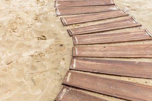 Wooden beach boardwalk, path with sand with copy space