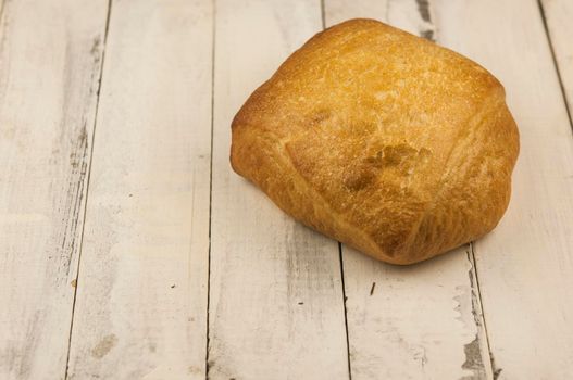 Bread, freshly baked at home, placed on a white wooden board