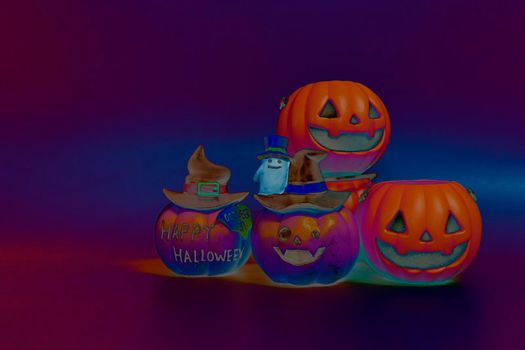 Jack o lantern pumpkin on a colorful dark background. Halloween concept backdrop