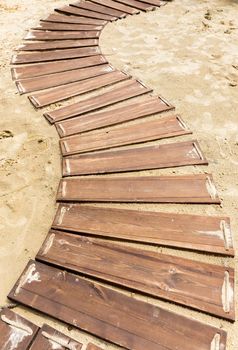 Wooden beach boardwalk, path with sand with copy space