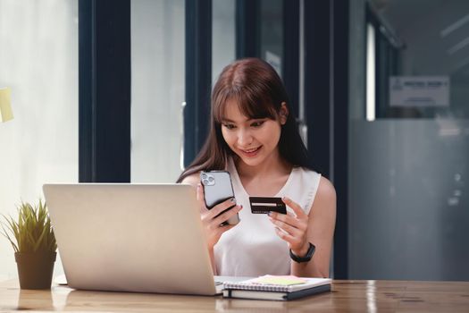 Woman enjoy with online shopping application and looking at credit card for fill number to payment.