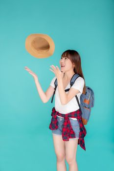 Beautiful portrait young asian woman smiling and throw hat and camera travel summer trip in vacation isolated on blue background, tourist asia girl cheerful journey with hobby in holiday concept.