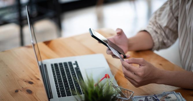 Online shopping concept, A man hands holding using mobile smart phone and credit card making online payment with smartphone.