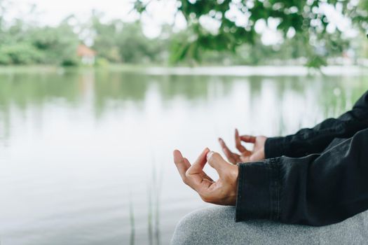 Woman practicing yoga lesson, breathing, meditating exercise, outdoor in grass field. Well being, wellness concept