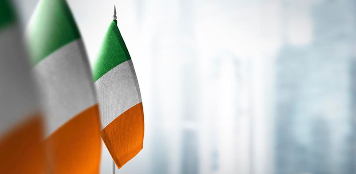 Small flags of Ireland on a blurry background of the city.