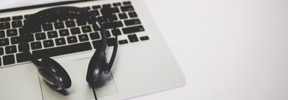 Laptop computer and headphone on desk, e-learning online, webinar for education and learning, seminar with notebook, video conference, headset for multimedia, course and classroom to internet.