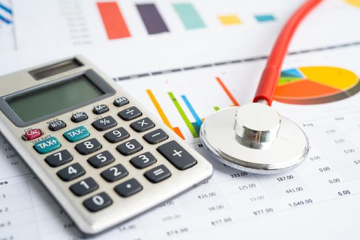 Stethoscope with calculator on chart graph paper, finance, account, statistic, analytic economy Business concept.