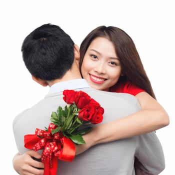 romantic moment: young man giving a rose to his girlfriend. Embracing couple hugging happy. Smiling interracial couple in love isolated on white background.