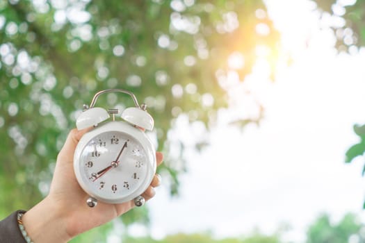 Selective focus of alarm clock with nature bokeh background. lifestyle  productive life concept.