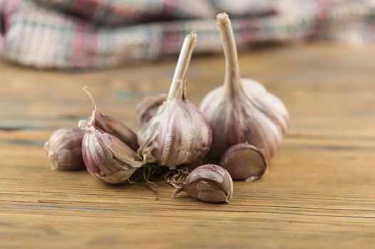 Organic garlic. Fresh garlic cloves and garlic bulb on a wooden table. Garlic for healthy eating. Concept of spices for healthy cooking. Closeup