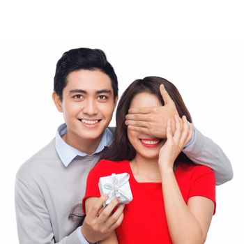 Asian man makes present to his lovely sweetheart. Young man giving a gift. Cheerful young couple man and woman at home offering to each other gifts for lover's valentine day