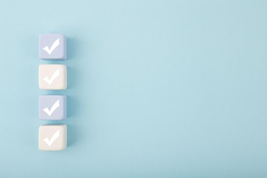 Four checkmarks against bright pastel blue background with copy space. Concept of questionary, checklist, to do list, planning, business or verification. Creative minimal composition 