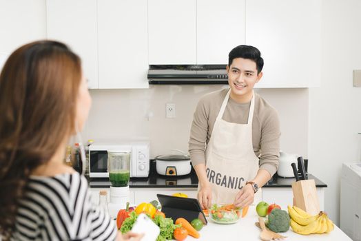 Asian wife waiting for food on a kitchen at home