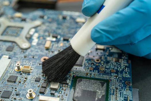 Technician use brush and air blower ball to clean dust in circuit board computer. Repair upgrade and maintenance technology.