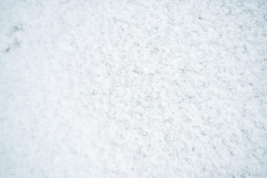 The texture of white untouched snow lying on the road.