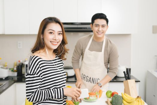 Asian wife waiting for food on a kitchen at home