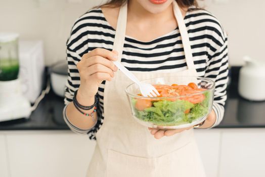 Young happy woman eating salad. Healthy lifestyle with green food.