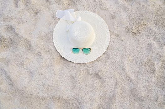 Hats and glasses are located on the sea blue sea beaches on a clear day