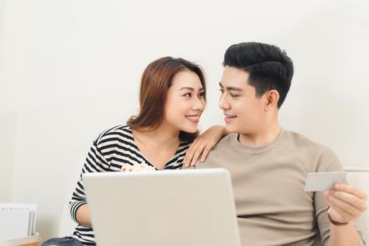 Young asian couple payment online using laptop and credit card