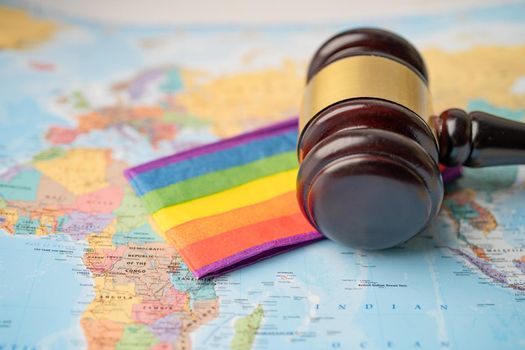 Bangkok, Thailand - December 1, 2020 LGBT rainbow flag with gavel for judge lawyer on world globe map.