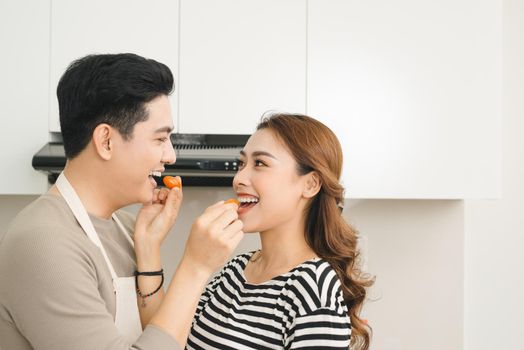 Portrait of happy asian young couple cooking together in the kitchen at home.