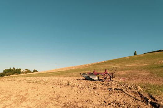Closeup of a plow standing on a hill in the idyllic Tuscan countryside, Tuscany, Italy.