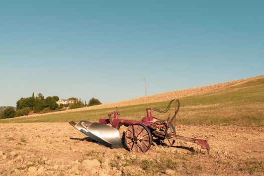 Closeup of a plow standing on a hill in the idyllic Tuscan countryside, Tuscany, Italy.