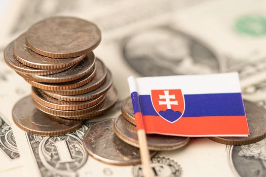 Stack of coins with Slovakia flag on US dollar banknotes background.