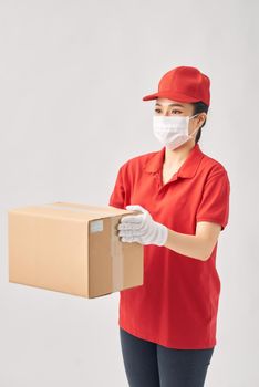 Delivery woman holding cardboard boxes in medical rubber gloves and mask on white background. 