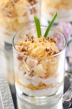 Chicken salad with pineapple, corn, seasoned with Greek yogurt, crushed nuts and grated cheese. A salad in a glass, a great idea for serving food in portions.
