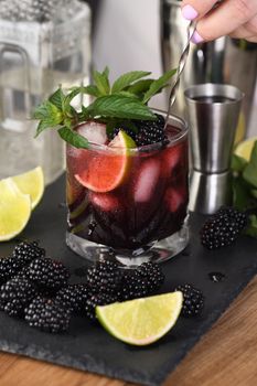 Blackberry summer mojito cocktail. Cold refreshing organic alcoholic drink with berries, lime, mint